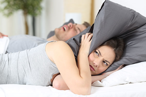 woman having trouble sleeping cause her husband snores